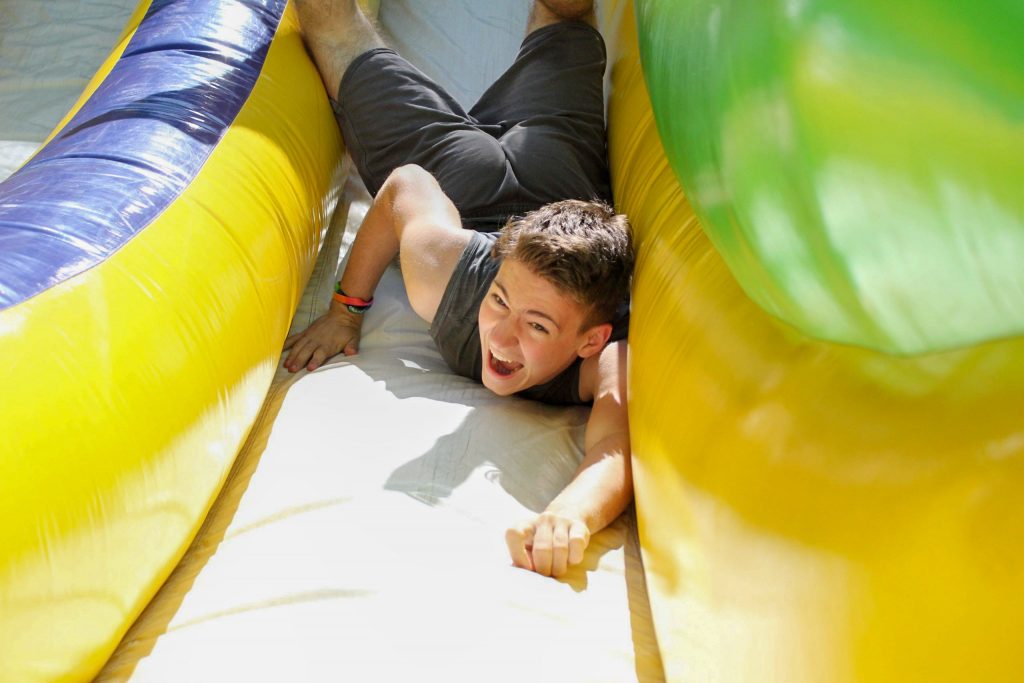 A camper plays on an inflatable obstacle course